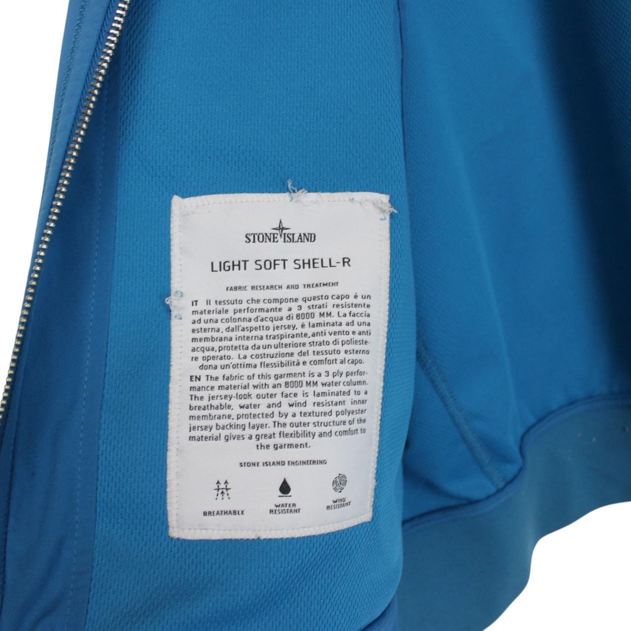 Stone Island blue full zip jacket with logo patch and soft shell material.