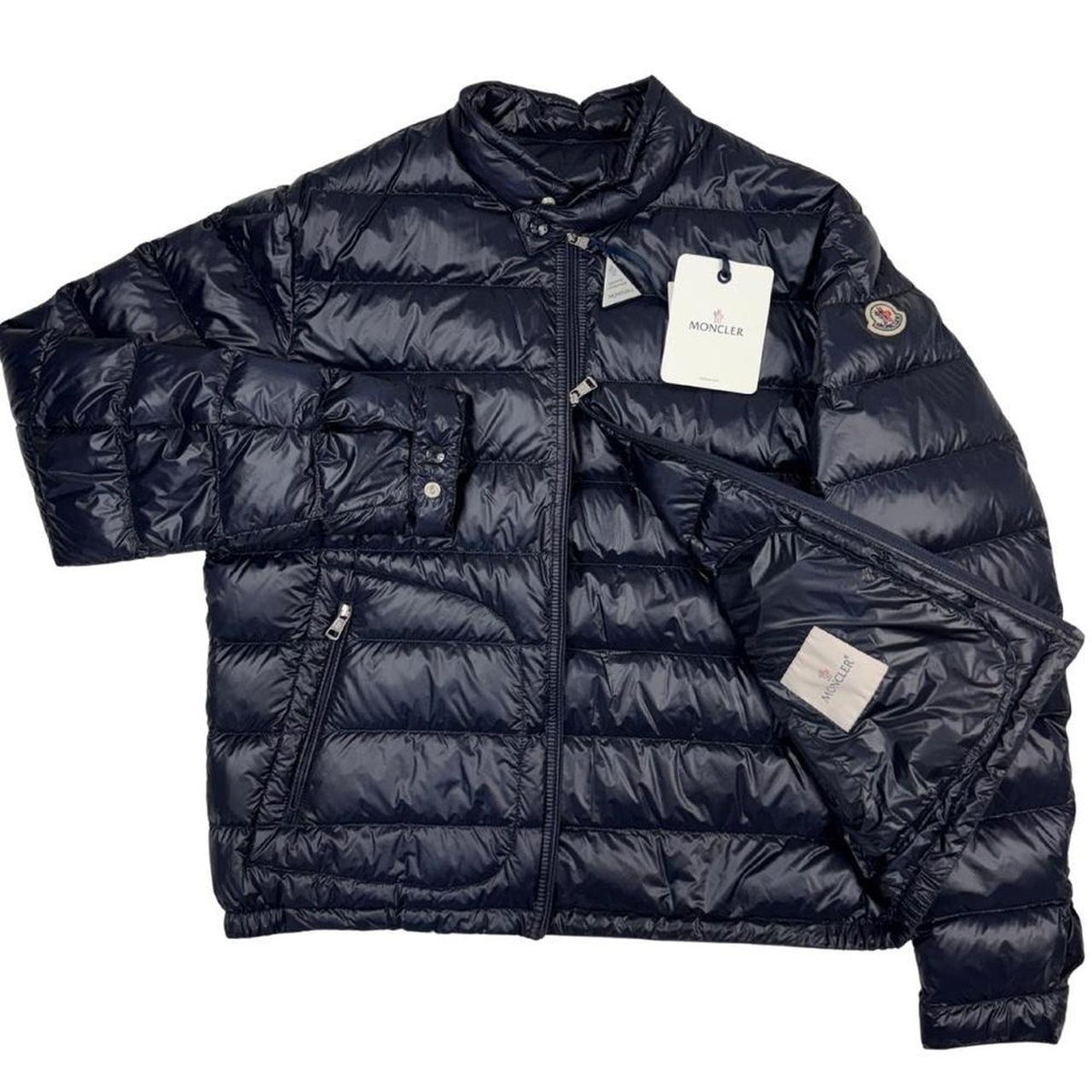 Moncler navy blue down jacket with full zip and logo patch on sleeve.