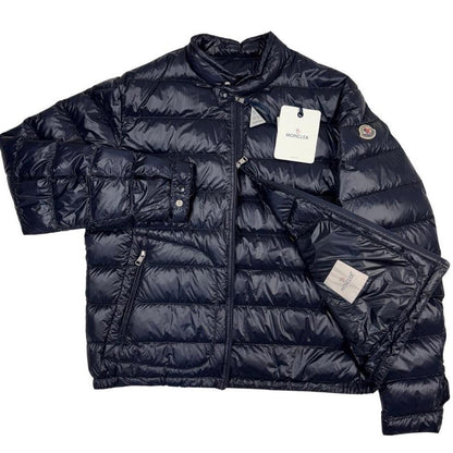 Moncler navy blue down jacket with full zip and logo patch on sleeve.