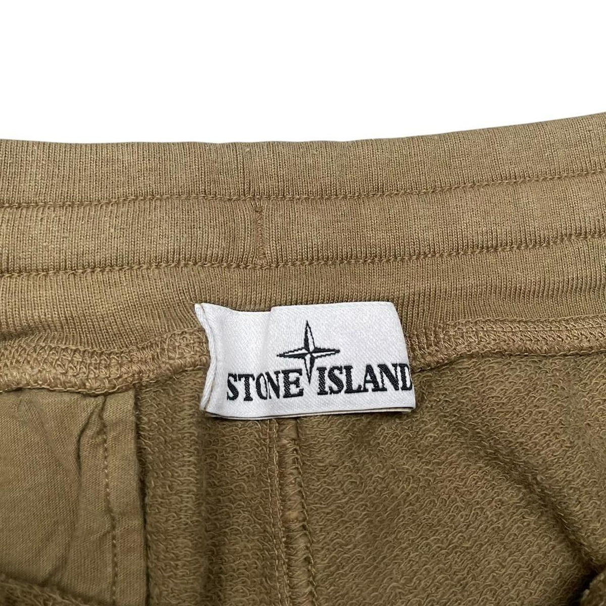 Stone Island khaki brown jogger shorts with logo patch and cotton material.