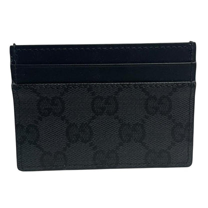 Gucci black card holder featuring Supreme GG monogram pattern in leather and canvas.