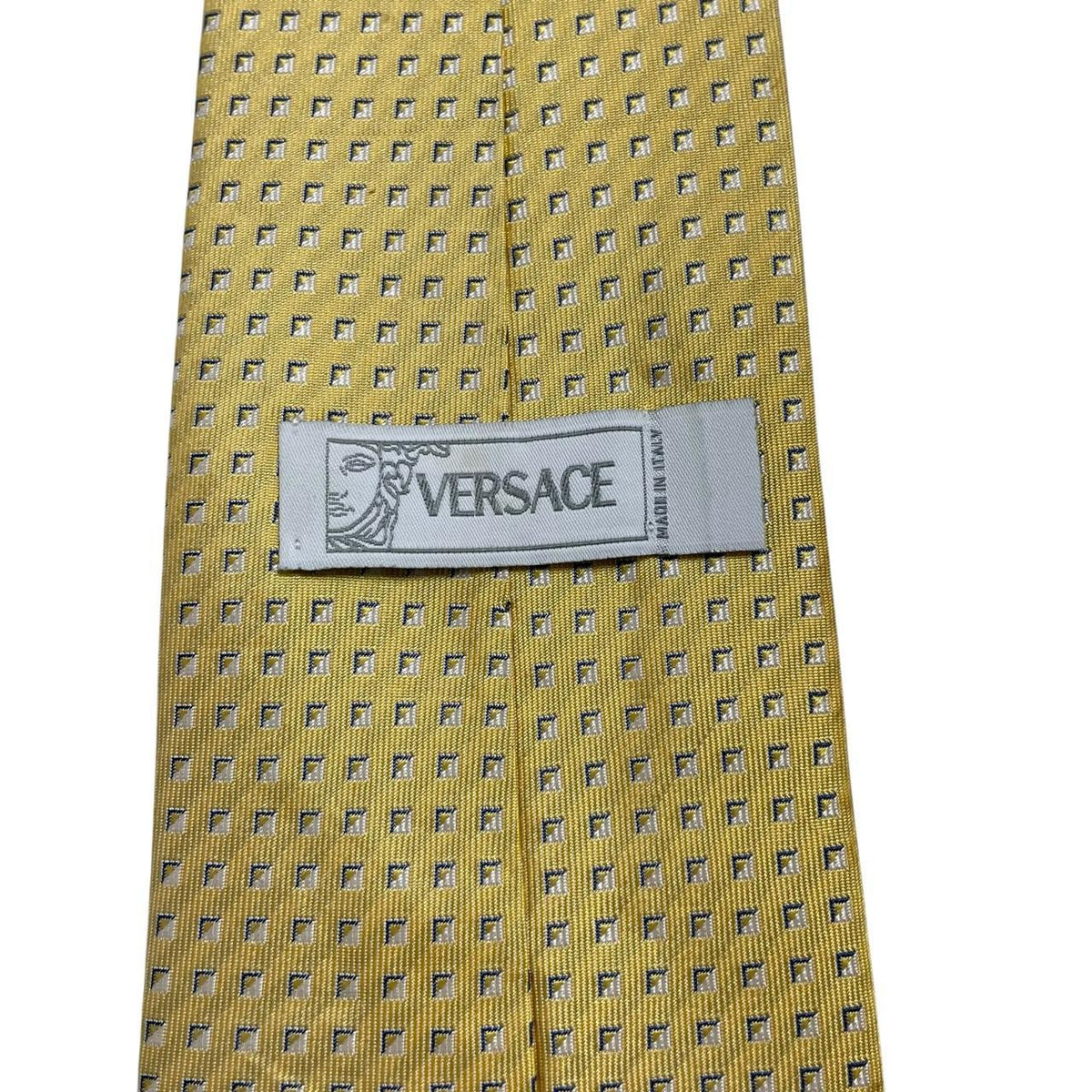 Versace yellow silk tie with subtle pattern and faint mark on front.