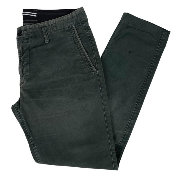 Stone Island green slim fit cotton trousers with logo patch and faded details.