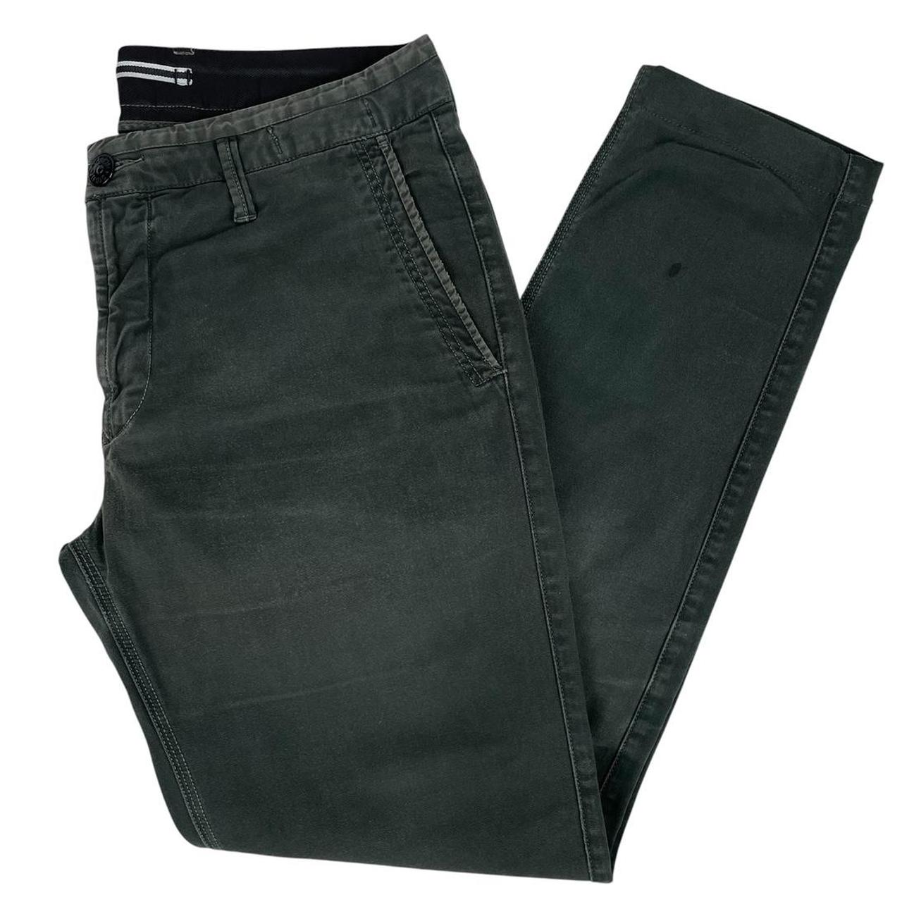 Stone Island green slim fit cotton trousers with logo patch and faded details.