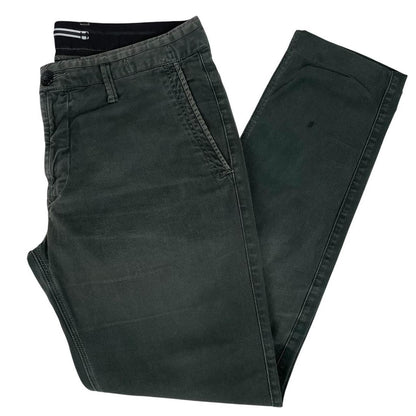 Stone Island green slim fit cotton trousers with logo patch and faded details.