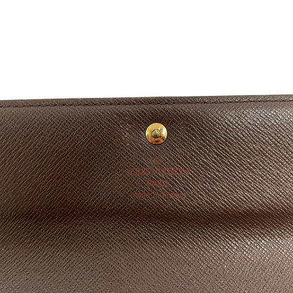 Louis Vuitton gold crossbody wallet Damier Ebene canvas with removable strap and logo.