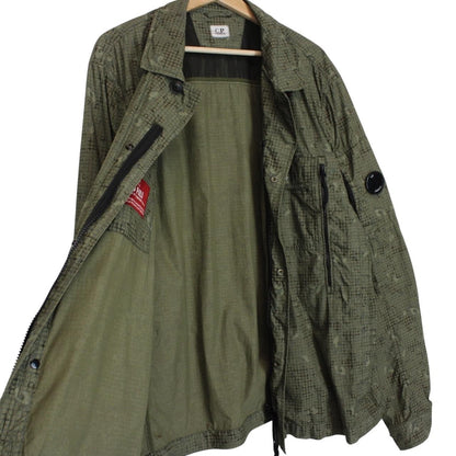 CP Company khaki green overshirt jacket with digital camouflage pattern and lens detail.