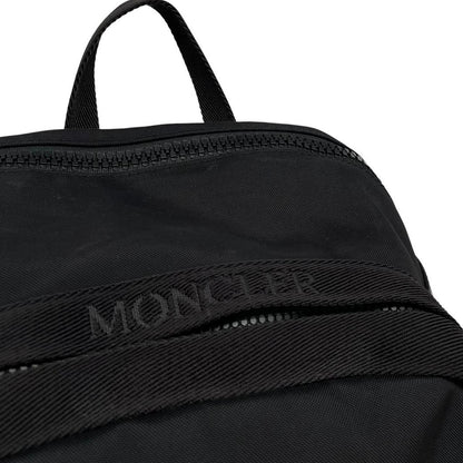 Moncler black duffel bag with logo patch and durable material, pre-loved condition.