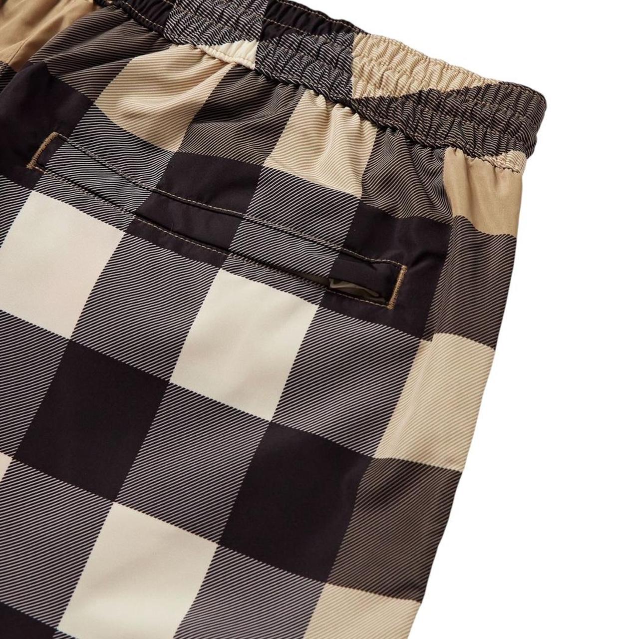 Burberry beige swim shorts featuring Nova Check pattern and nylon material.