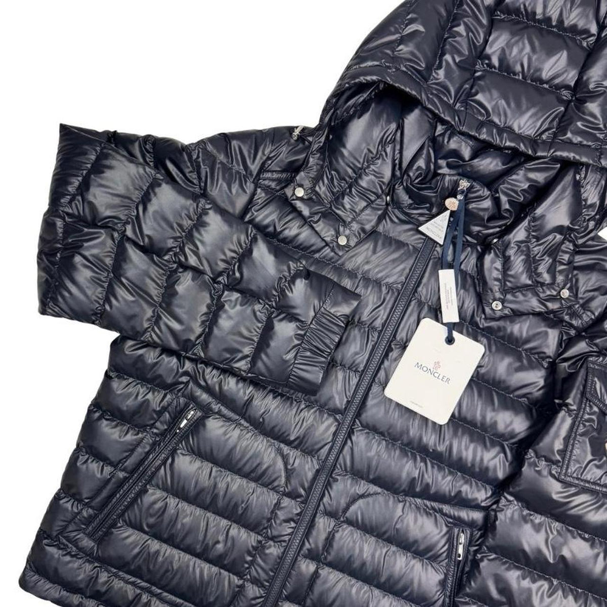 Moncler navy blue hooded puffer jacket with logo patch and nylon material.