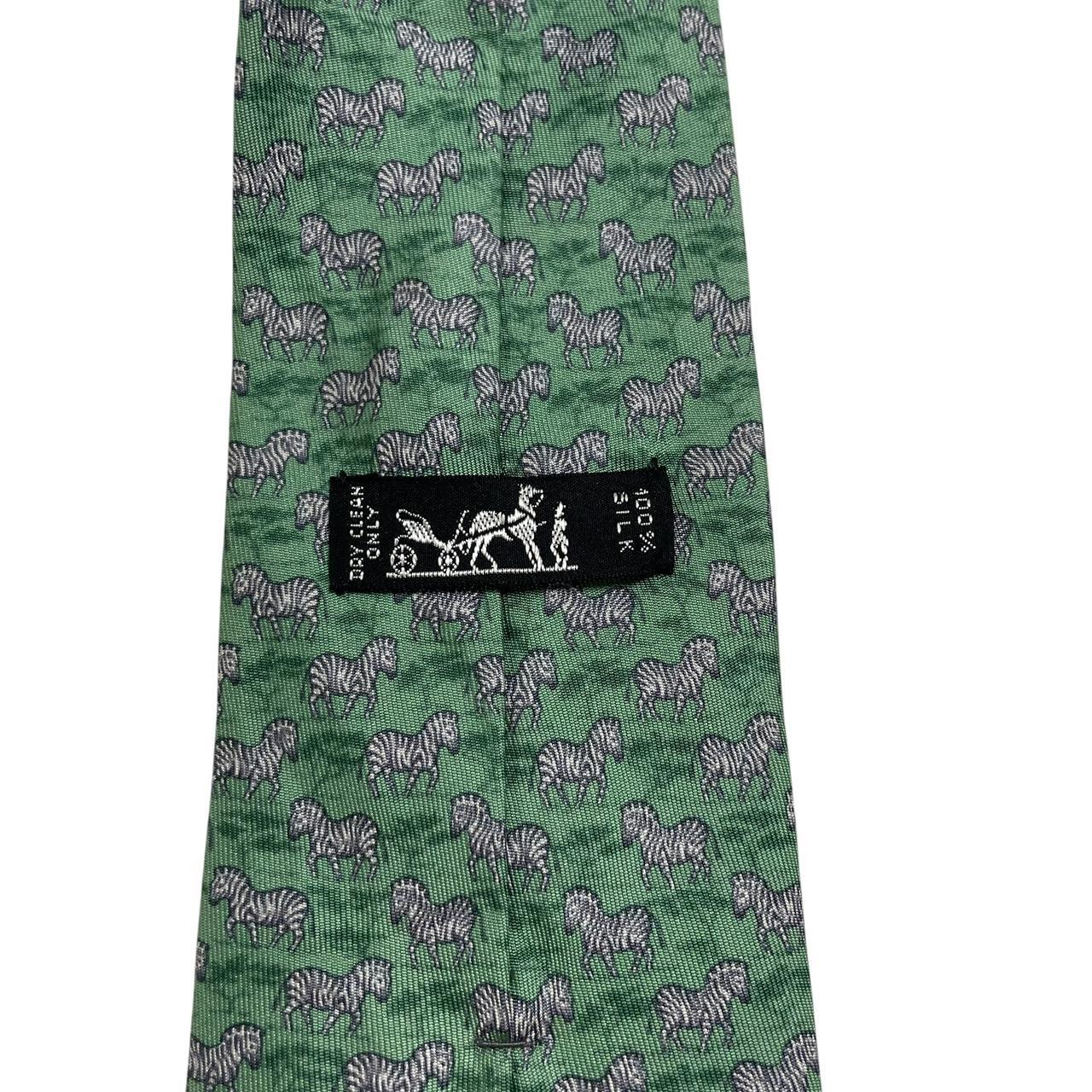 Hermes green silk tie featuring zebra print design and logo detail.