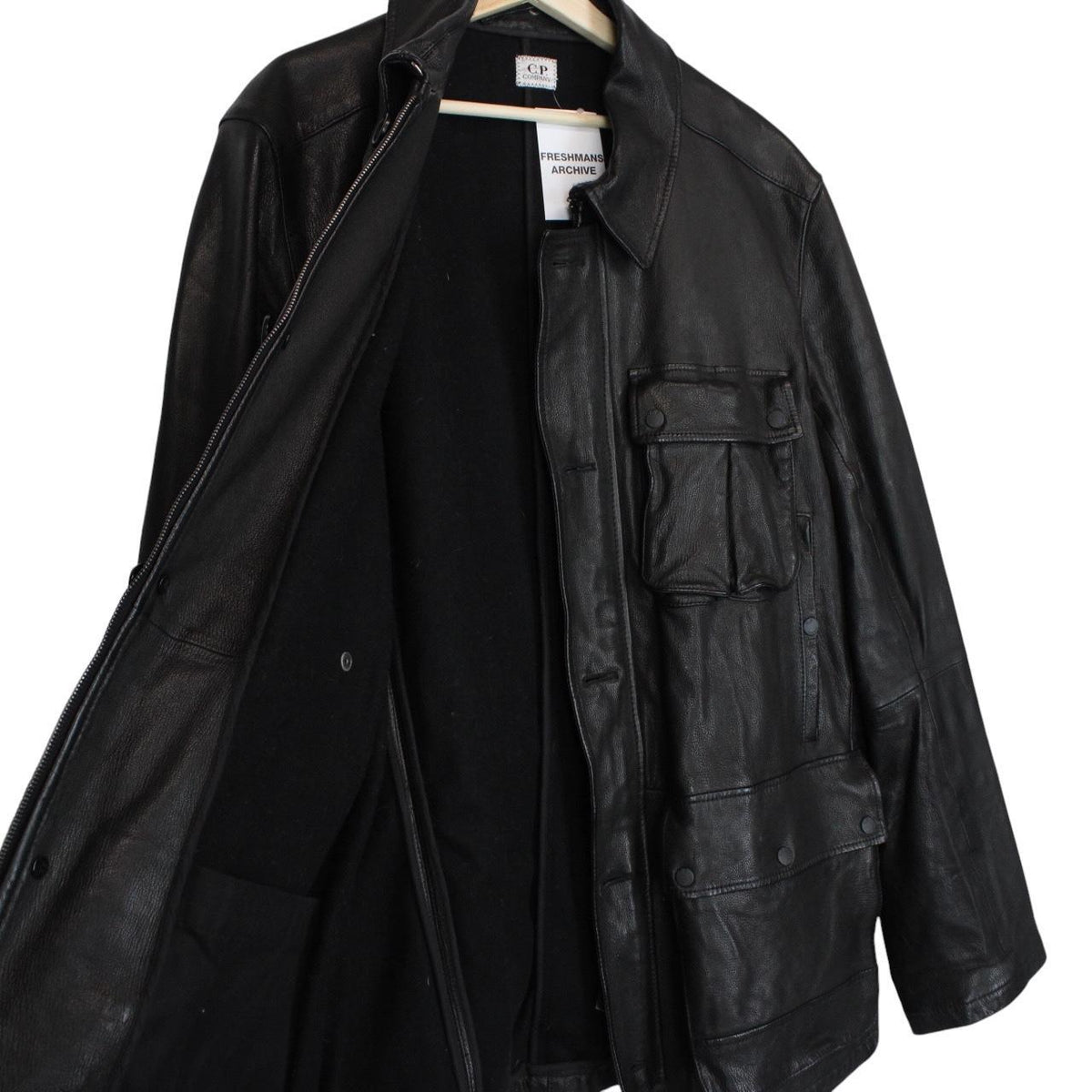 CP Company black leather jacket with multi pockets and logo detail.