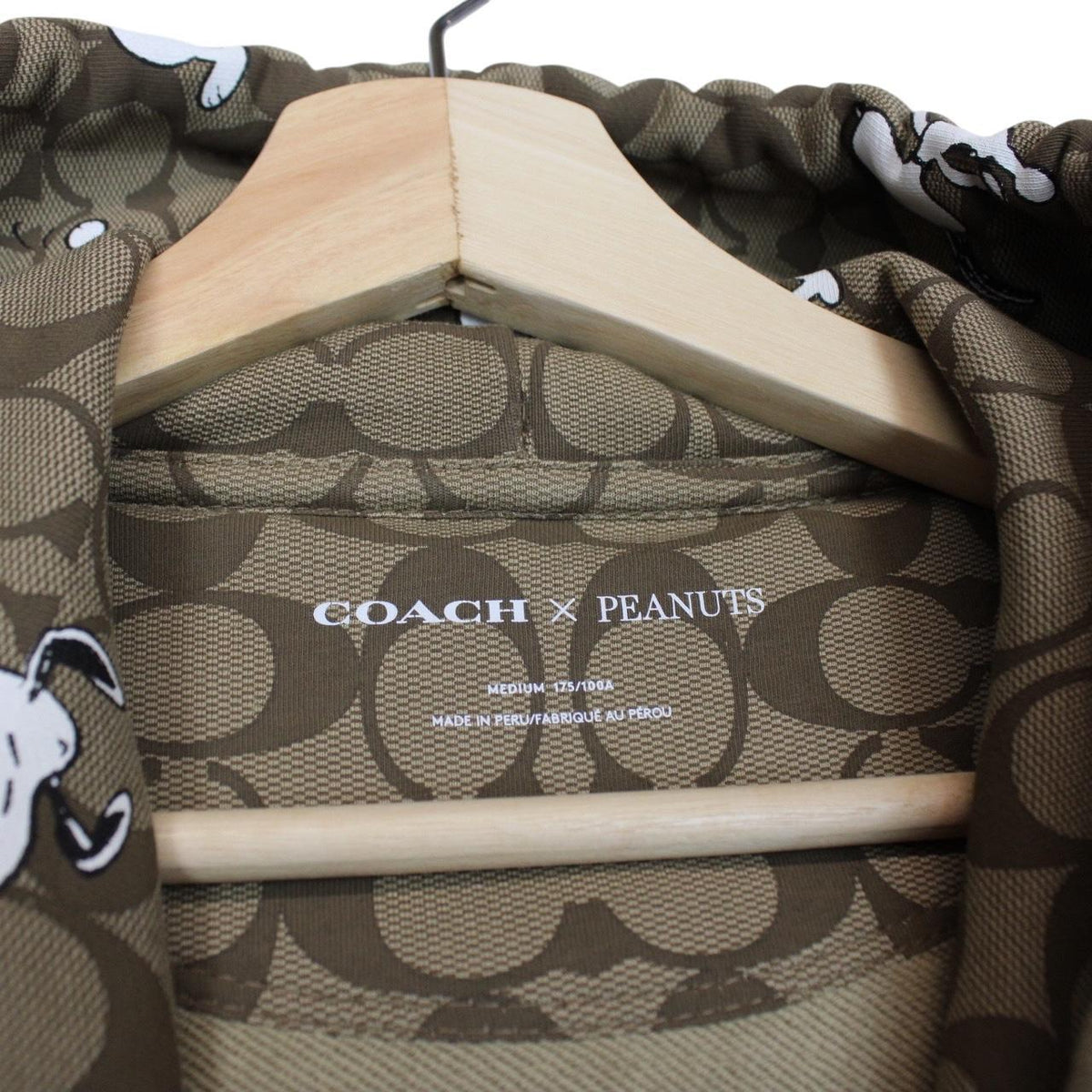 Coach brown hoodie featuring Peanuts Snoopy graphic and full zip design.