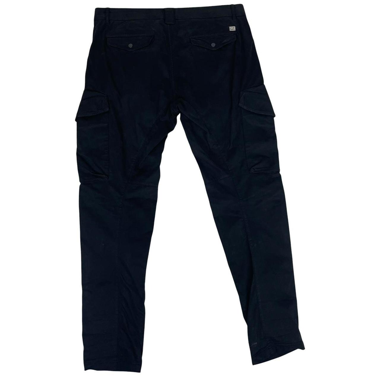 CP Company navy blue tapered fit cargo trousers with lens detail and pockets.