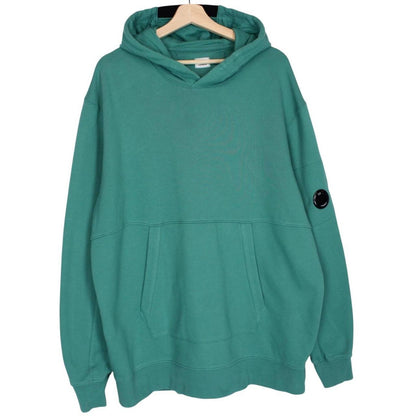 CP Company green hoodie jumper with lens detail and cotton material.