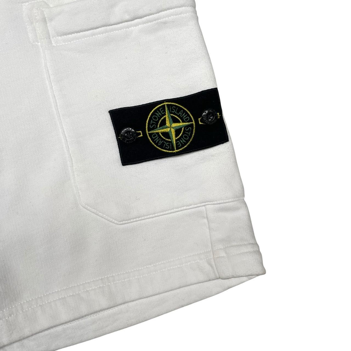 Stone Island white jogger shorts with logo patch and cotton material.