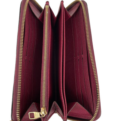 Louis Vuitton black leather wallet with monogram pattern and embossed logo.
