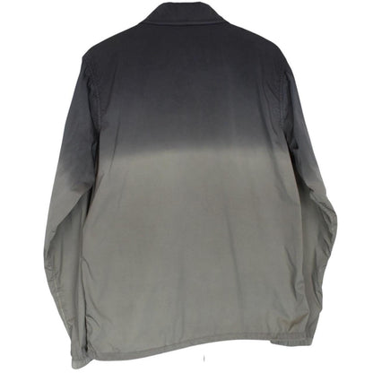 CP Company khaki green and grey jacket with shibori pattern and lens detail.