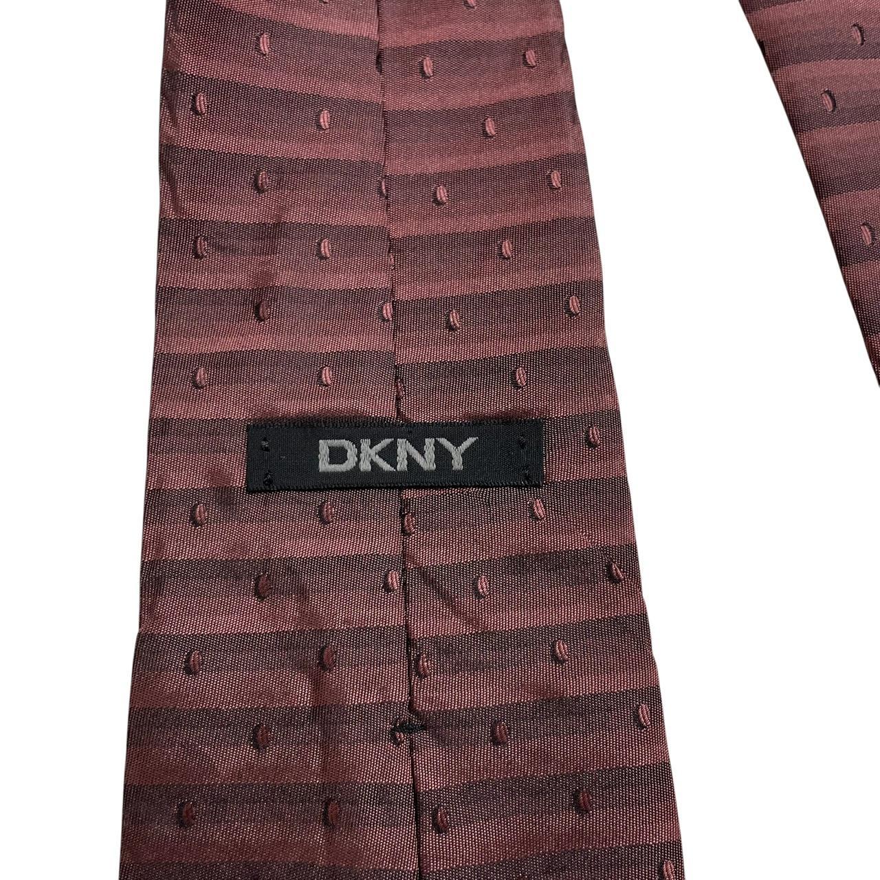 DKNY burgundy silk tie with striped pattern and logo detail.