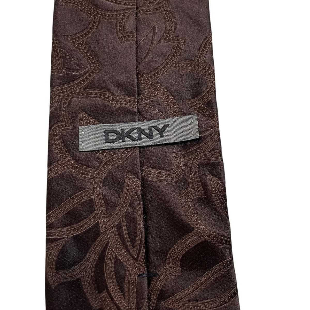 DKNY brown silk tie with vintage floral pattern and logo detail.