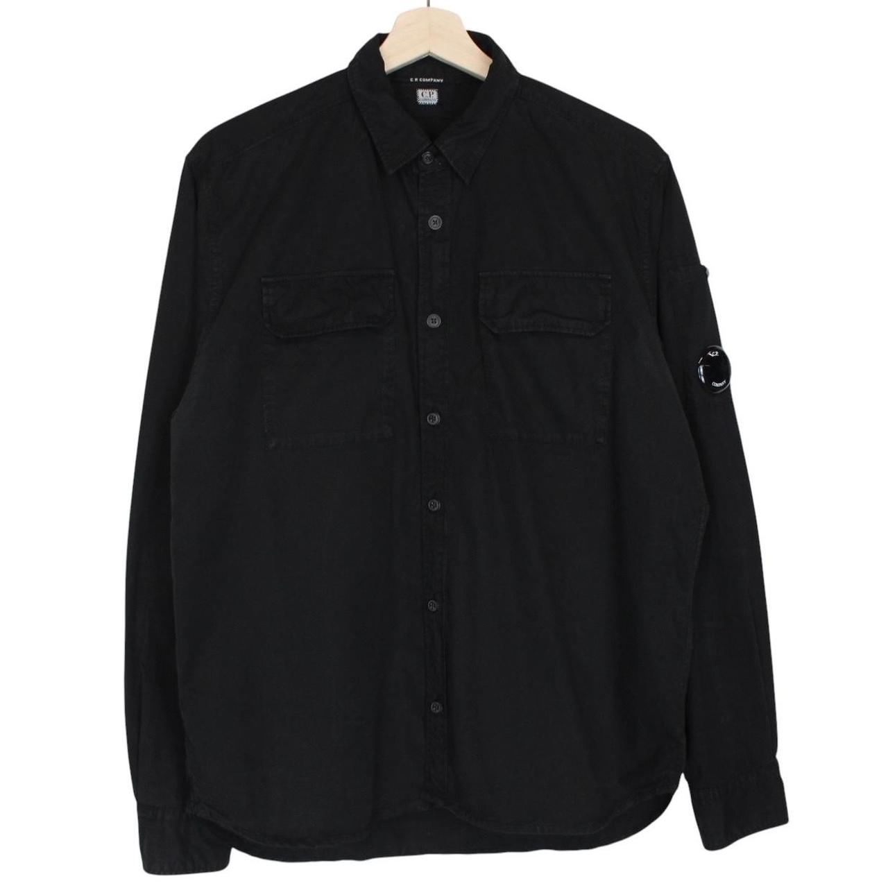 CP Company black button-up jacket with lens detail and cotton material.