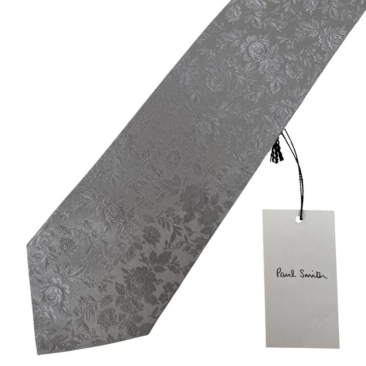 Paul Smith silver silk tie with floral print and brand logo detail.