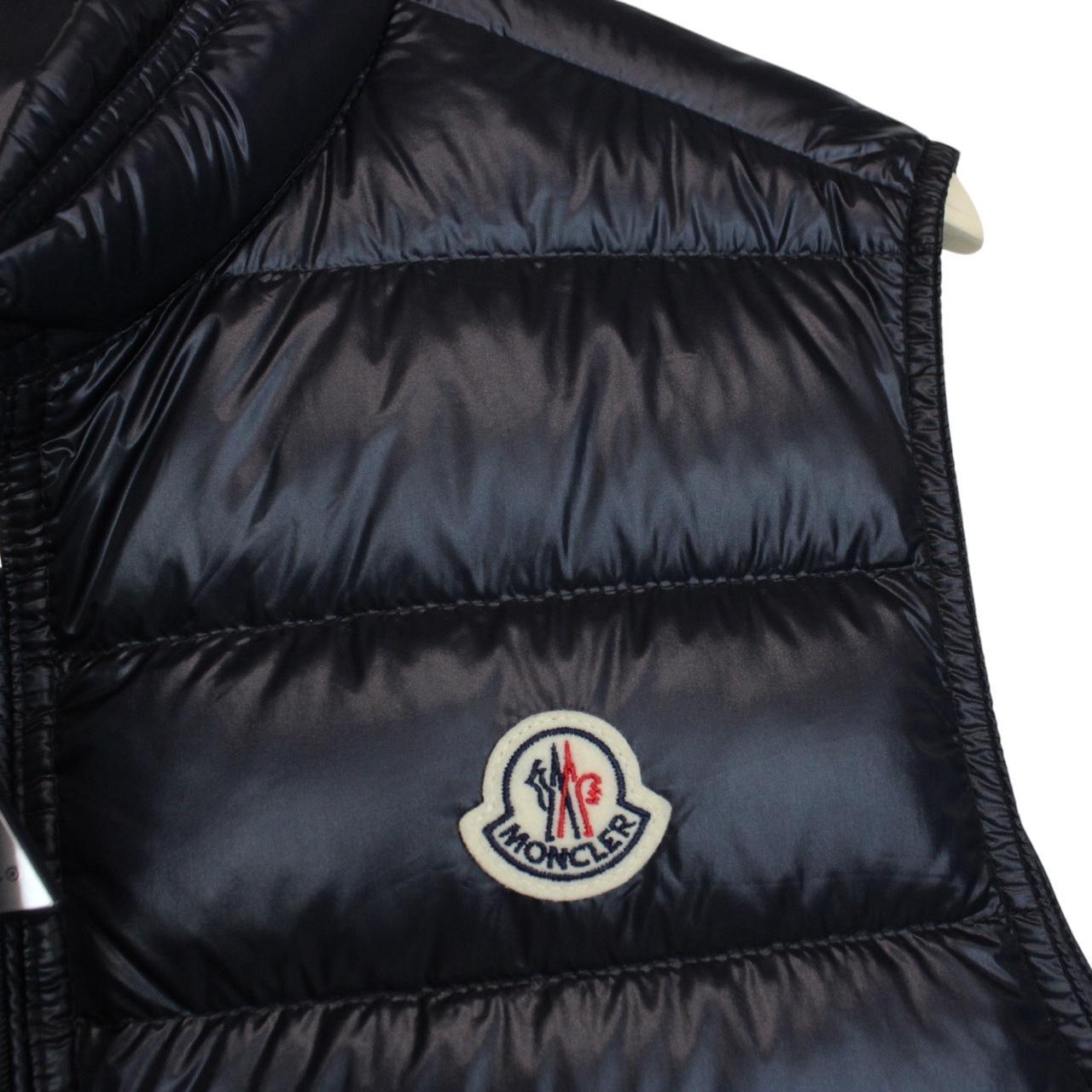 Moncler navy blue down gilet with logo patch and quilted design.
