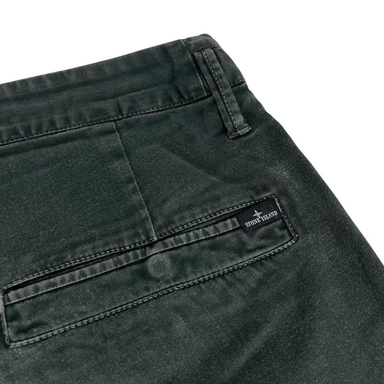 Stone Island green slim fit cotton trousers with logo patch and faded details.