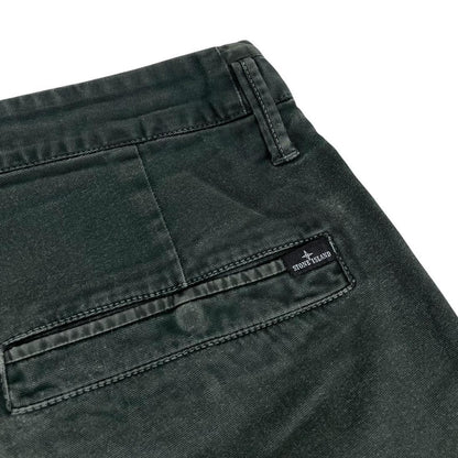 Stone Island green slim fit cotton trousers with logo patch and faded details.