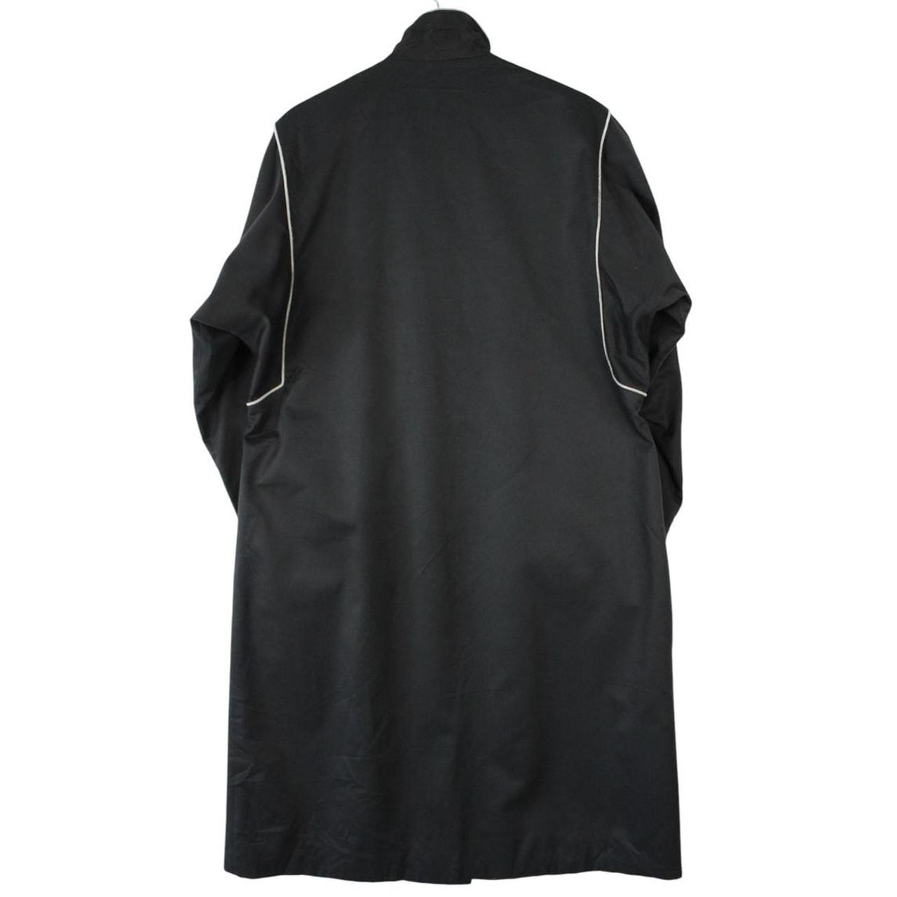 Burberry black cotton trench coat with single breasted design and classic logo detailing.