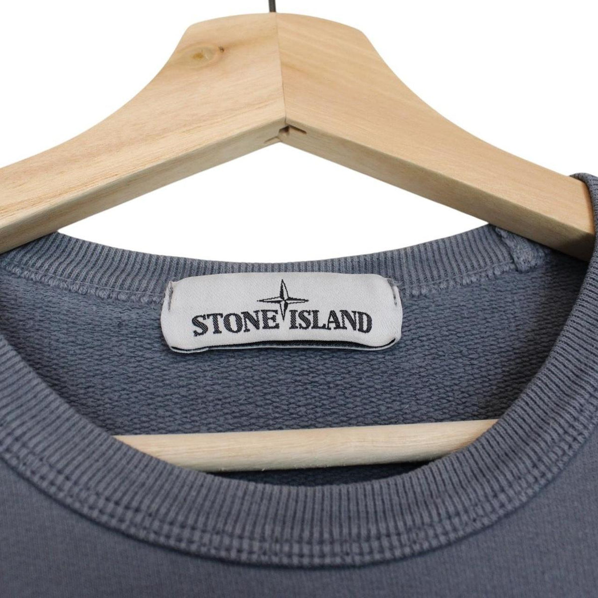 Stone Island blue cotton sweatshirt with iconic compass logo and ribbed cuffs.