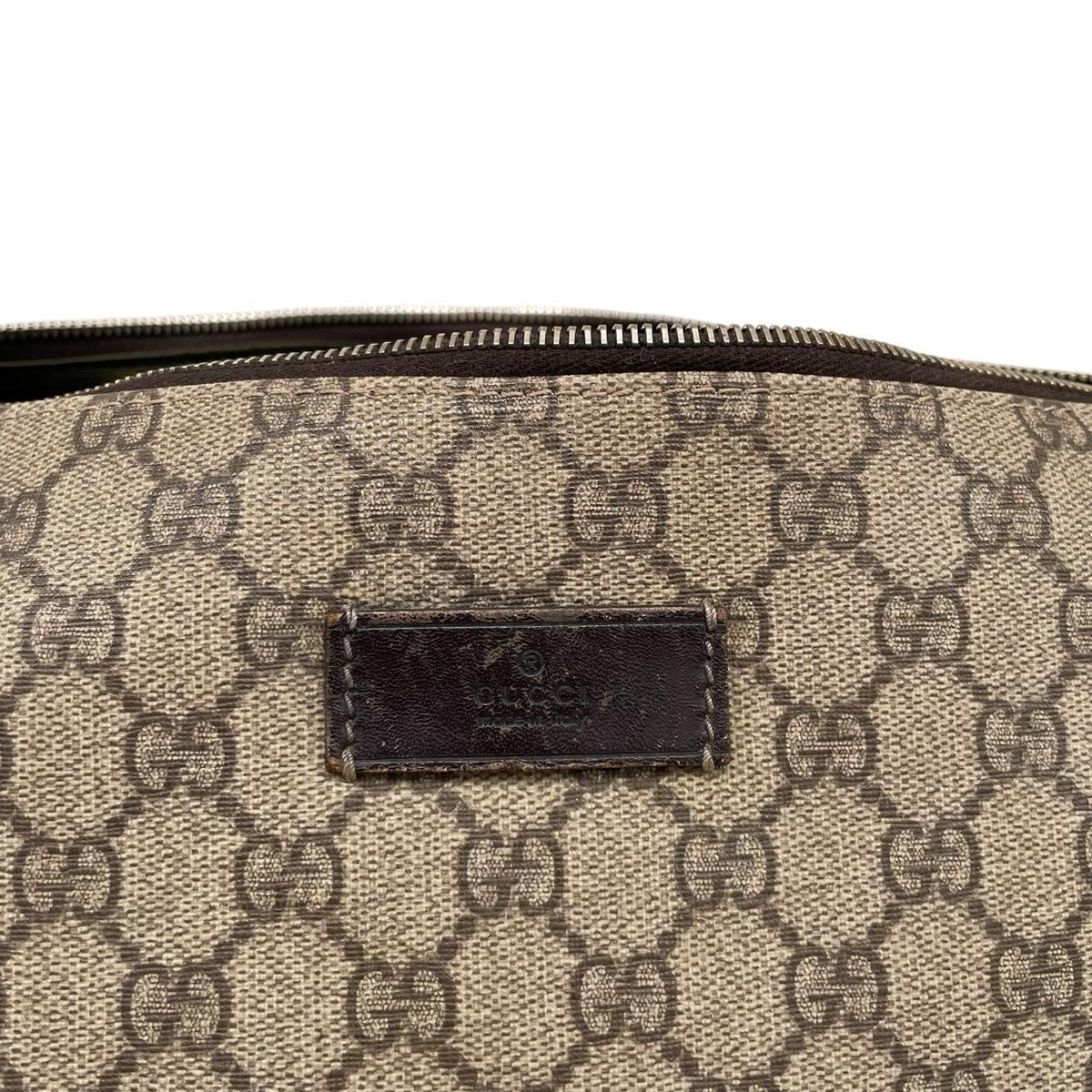 Gucci brown diaper changing bag with Supreme GG monogram and leather shoulder strap.