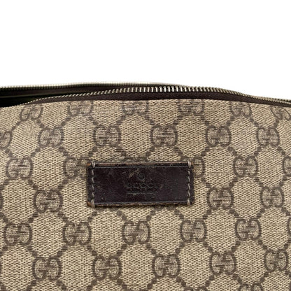 Gucci brown diaper changing bag with Supreme GG monogram and leather shoulder strap.