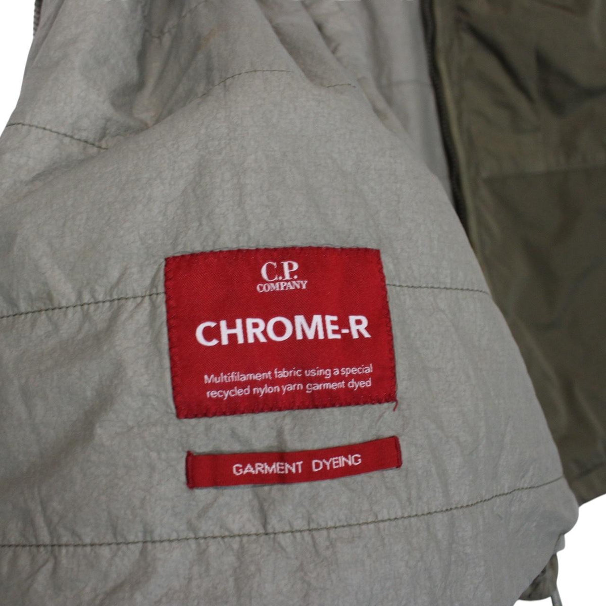 CP Company green hooded jacket with chrome detailing and logo patch on sleeve.
