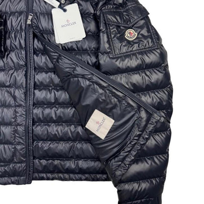 Moncler navy blue hooded puffer jacket with logo patch and nylon material.