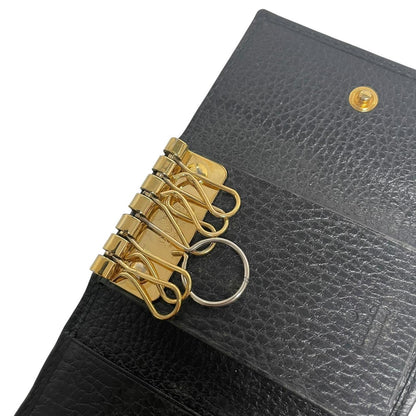 Gucci black leather key case with GG logo and quilted pattern.