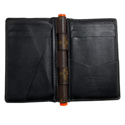 Louis Vuitton brown purse with orange metal hardware and iconic monogram pattern.