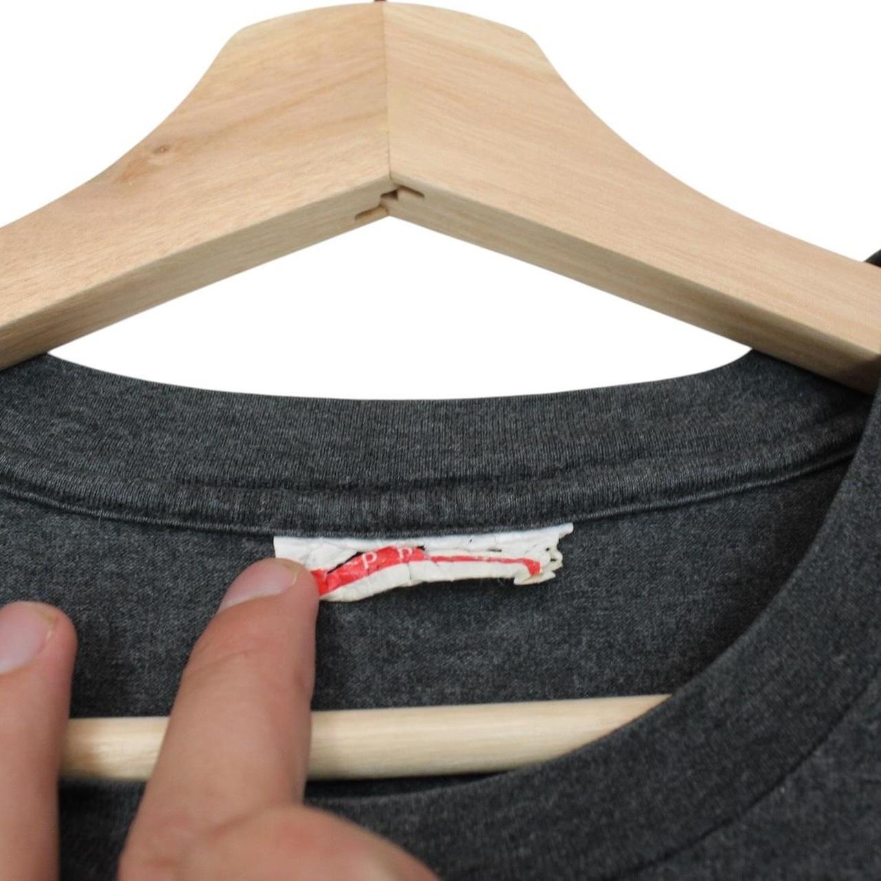 Prada grey cotton t-shirt with red logo and pocket detail, vintage style.