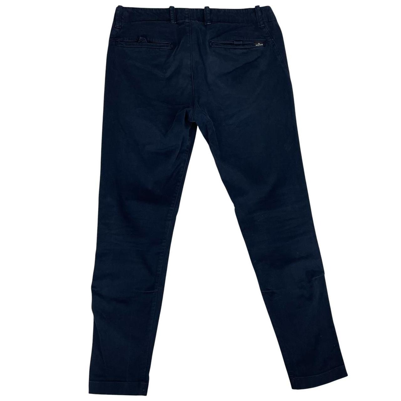 Stone Island navy blue skinny fit cotton trousers with logo patch and subtle wear.