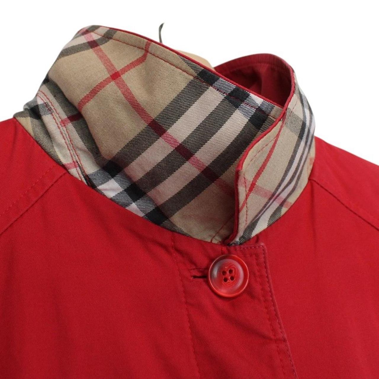 Burberry red trench coat with Nova Check pattern and belted waist detail.