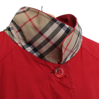 Burberry red trench coat with Nova Check pattern and belted waist detail.