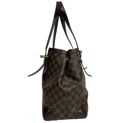Louis Vuitton brown duffel bag with Damier Ebene pattern and logo plaque details.