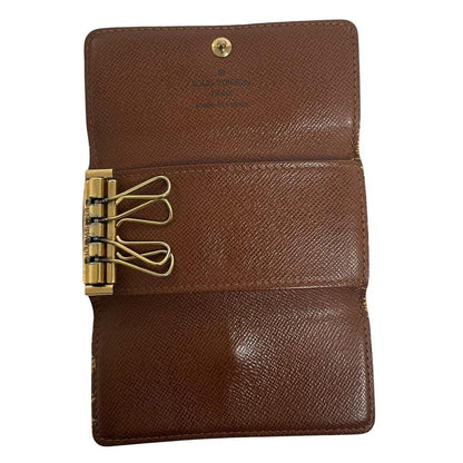 Louis Vuitton brown and tan monogram canvas key case with logo detail.