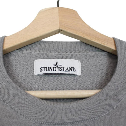 Stone Island grey wool knit jumper with logo patch and subtle wear marks.