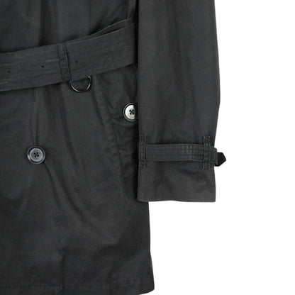 Burberry black trench coat featuring Nova Check pattern, double-breasted design, and belted waist.