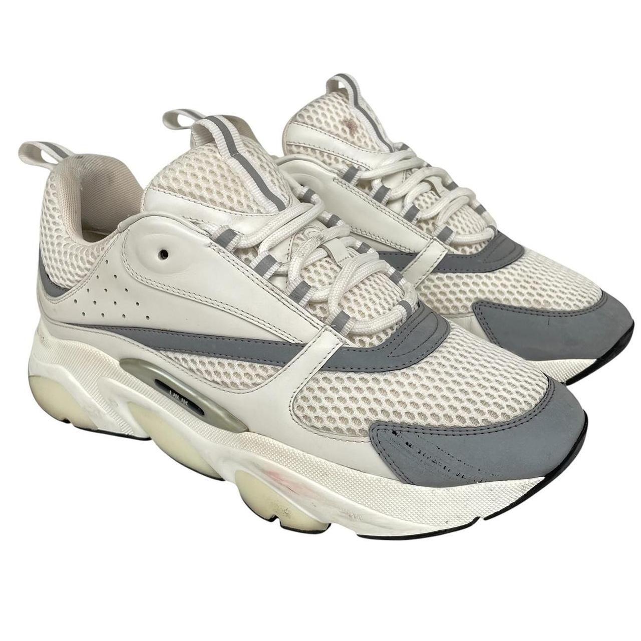 Dior grey and white trainers with logo detailing and worn soles.