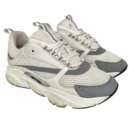 Dior grey and white trainers with logo detailing and worn soles.
