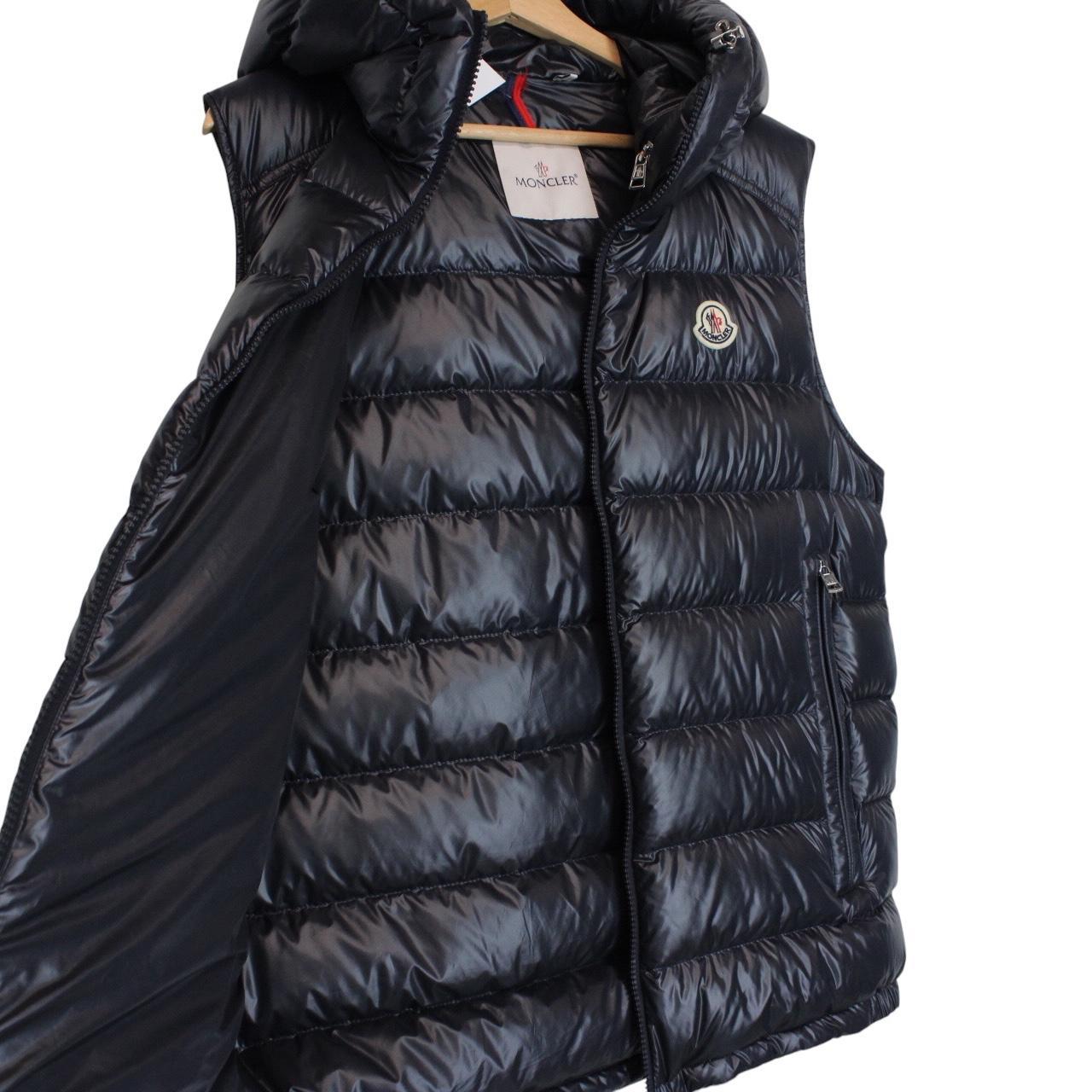 Moncler navy blue hooded nylon down gilet with logo and quilted texture.