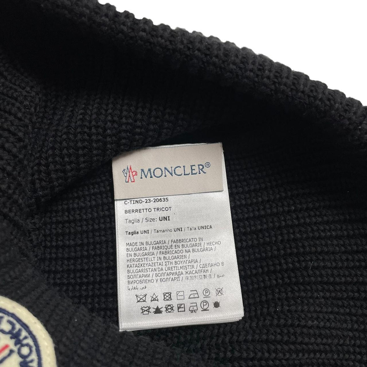 Moncler black ribbed knit beanie hat with embroidered logo detail.