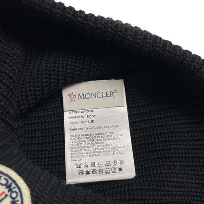 Moncler black ribbed knit beanie hat with embroidered logo detail.